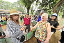 Des visiteurs étrangers portent des serpents non venimeux avec curiosité. Photo : CVN