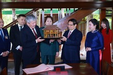 Le Premier ministre Pham Minh Chinh offre son homologue kirghize Adylbek Kasimaliev la maison sur pilotis miniature. Photo : VNA.
