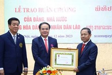 Khamlay Sipraseuth, membre du Comité central du Parti et vice-président permanent du Comité central du Front lao pour la construction nationale décerne l'Ordre Itsara (Liberté), troisième classe, au vice-ministre de l'Intérieur Vu Chiên Thang. Photo : VNA.
