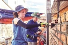 Deux jeunes Américains posent des briques dans la province de Quang Ngai, au Centre. Photo : CVN.