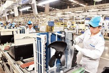 Les travailleurs assemblent des climatiseurs sur la chaîne de production dans une usine de Daikin Vietnam. Photo : Dang Minh/NDEL.