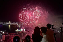 Des touristes regardent un feu d’artifice dans la ville de Dà Nang. Photo : VNA.