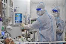Des médecins soignent un patient atteint du COVID. Photo : VNA.