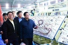 Le Premier ministre Pham Minh Chinh visite une chaîne de production d'une entreprise à Quang Nam. Photo : VNA.