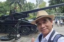 Le journaliste Huy Thang pose pour une photo souvenir avec des objets de guerre. Photo fournie par le personnage