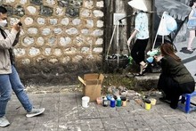 Une visiteuse veut participer au travail des artistes. Photo: CVN