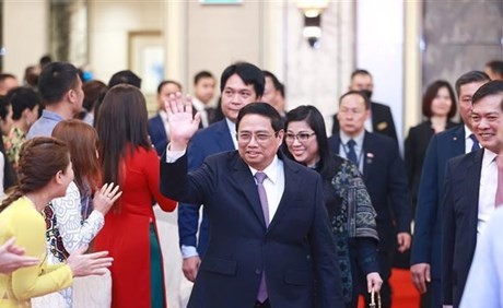 Le Premier ministre Pham Minh Chinh et son épouse lors de la rencontre avec communauté vietnamienne à Singapour, le 8 février 2023. Photo : VNA.