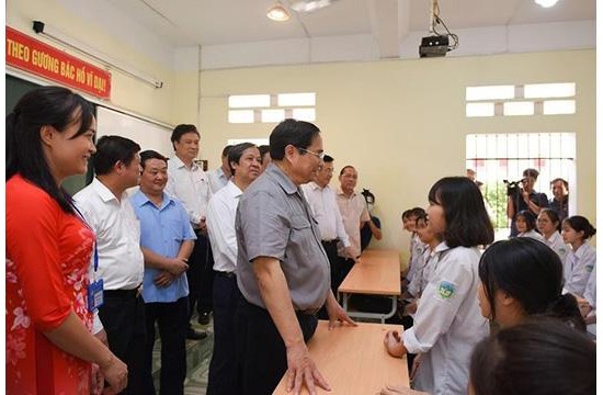 Le Premier ministre Pham Minh Chinh et des élèves de l’école primaire du bourg de Yen Lap. Photo : NDEL.