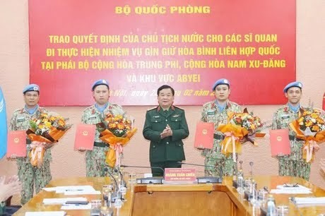 Le général de corps d’armée Hoàng Xuân Chiên, vice-ministre de la Défense remet les décisions du président de la République à quatre officiers envoyés aux missions de maintien de la paix de l’ONU. Photo : VNA.
