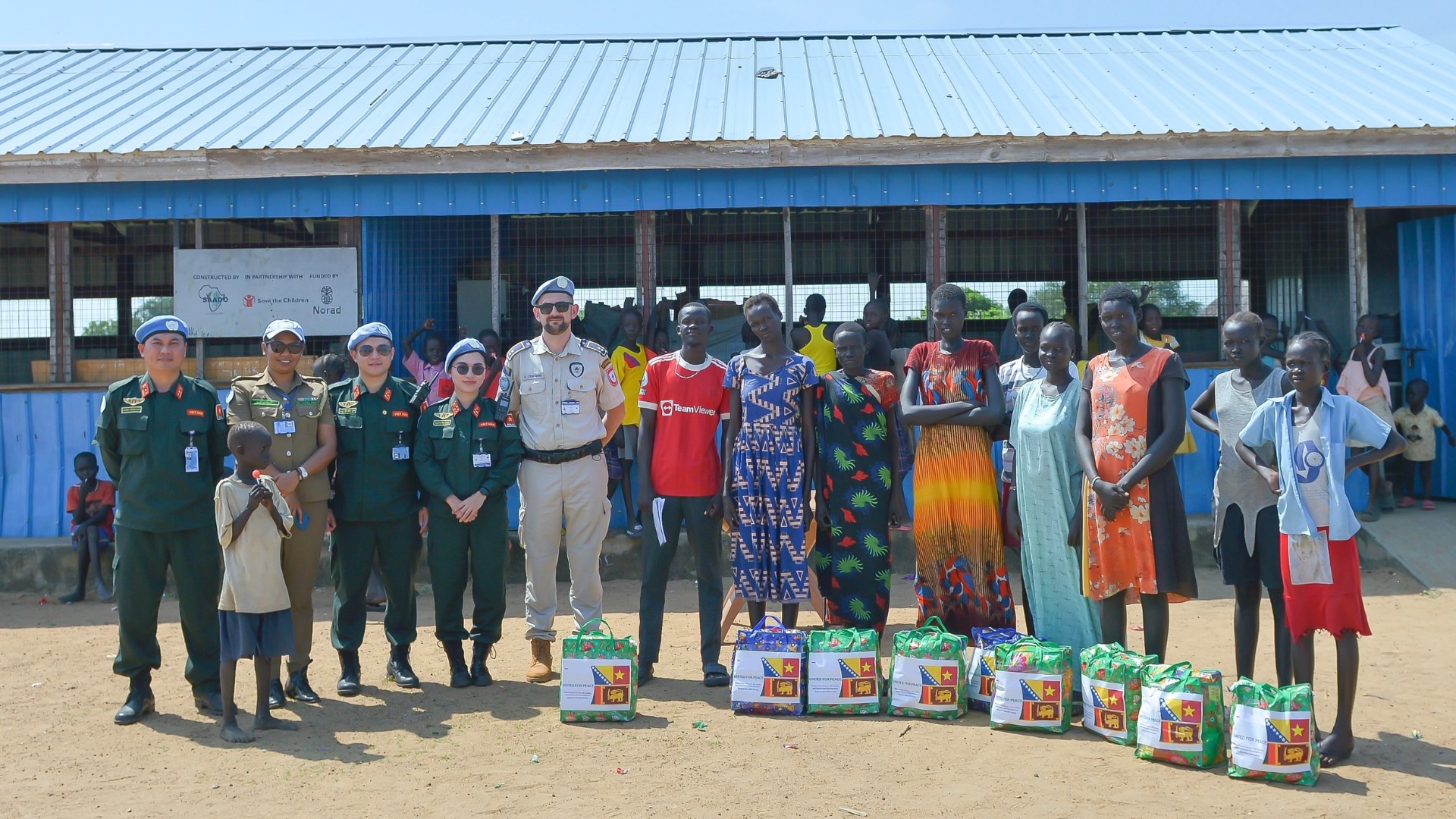 Des agents de l'Unité de maintien de la paix n°4 de la police vietnamienne offrent des cadeaux aux habitants d'un camp temporaire au Soudan du Sud. Photo : VNFPU1.