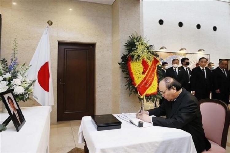 Le Président Nguyên Xuân Phuc écrit dans le registre de condoléances en mémoire de feu le Premier ministre Abe. Photo : baoquocte.