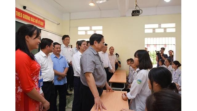 Le Premier ministre Pham Minh Chinh et des élèves de l’école primaire du bourg de Yen Lap. Photo : NDEL.