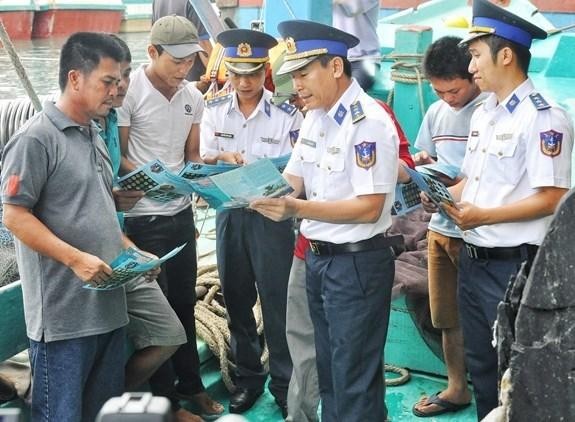 Des cadres de la Région des Garde-côtes No 3 aident des pêcheurs à mieux comprendre les réglementations sur les activités en mer. Photo: qdnd.vn