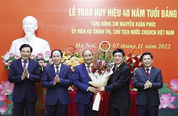 Des dirigeants félicitent le Président Nguyên Xuân Phuc (au milieu). Photo : VNA.