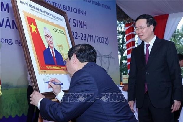 Le Premier ministre Pham Minh Chinh signe sur la peinture de timbres. Photo : VNA