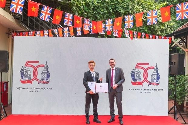 L’ambassadeur britannique Iain Frew (à droite) et le gagnant du concours de création du logo pour célébrer le 50e anniversaire de l’établissement des relations diplomatiques entre le Royaume-Uni et le Vietnam, Ngô Quang Trung. Photo : VNA.