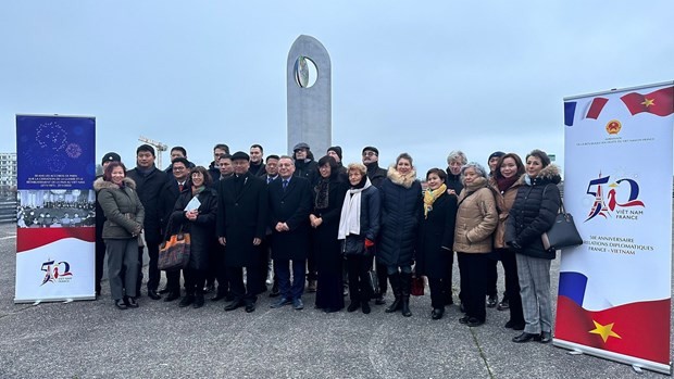 Prise de photos souvenir sur la place des Accords de Paris, où le symbole de paix du Vietnam a été inauguré en 2013 à l'occasion du 40e anniversaire de la signature de cet accord historique. Photo : VNA.
