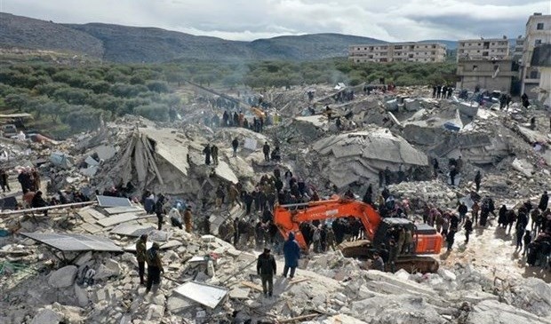 Des secouristes et volontaires recherchent des victimes et des survivants piégés dans les décombres après le tremblement de terre dans le village de Besnia, près de la frontière turque, dans la province d'Idlib, en Syrie. Photo : AFP/VNA