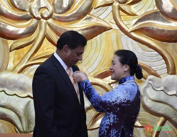 La présidente de la VUFO, Nguyên Phuong Nga attache l’Insigne de l’amitié à l’ambassadeur du Sri Lanka au Vietnam Prasanna Gamage sur la poitrine. Photo: VNA