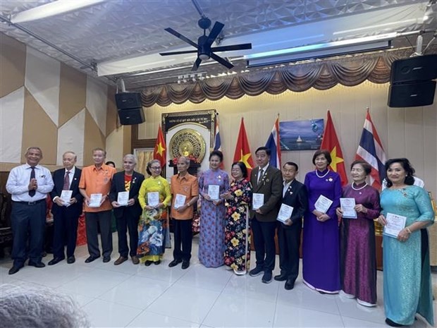  L'ancienne vice-présidente vietnamienne Truong My Hoa, qui est présidente du Fonds de bourses d'études Vu A Dinh - club "Pour Hoàng Sa - Truong Sa bien-aimés", remet des certificats d'adhésion à ce club à 33 Viet-kieu vivant à Udon Thani. Photo : VNA.