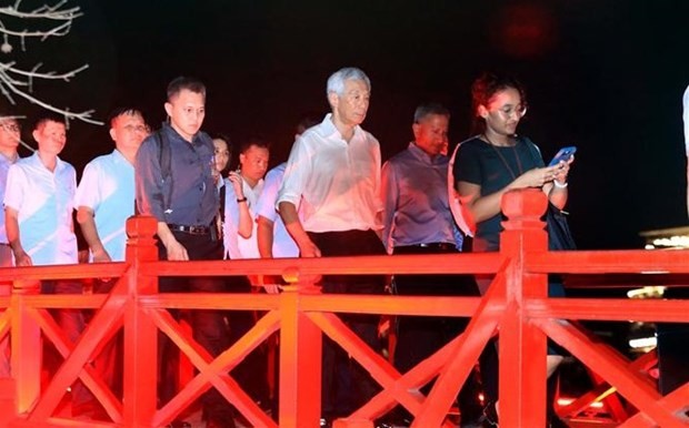 Le Premier ministre singapourien, Lee Hsien Loong, marche sur le pont The Huc. Photo : VNA.