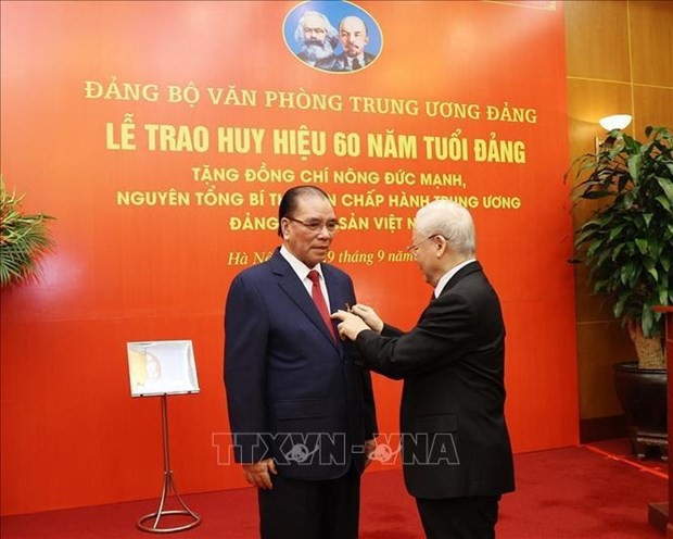 Le Secrétaire général Nguyên Phu Trong (à droite) remet l’Insigne des 60 ans d’appartenance au Parti à l’ancien Secrétaire du Parti Nông Duc Manh. Photo : VNA.