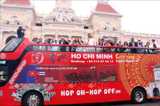 Les responsables effectuent une visite de la ville à bord de deux bus à impériale. Photo: VNA