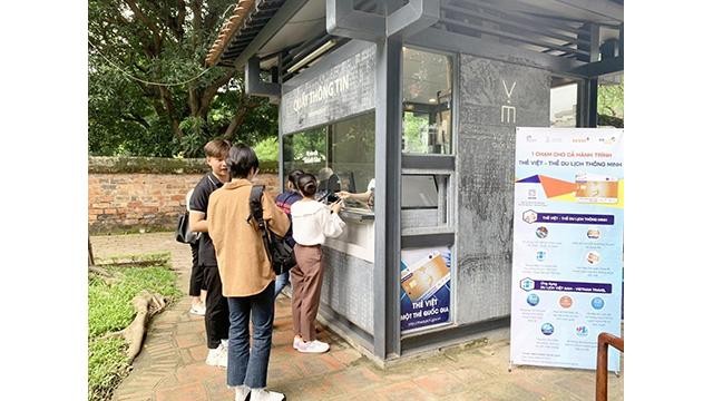 Les visiteurs s'inscrivent et activent la carte intelligente au comptoir d'information du Temple de la Littérature. Photo : Administration nationale du Tourisme.