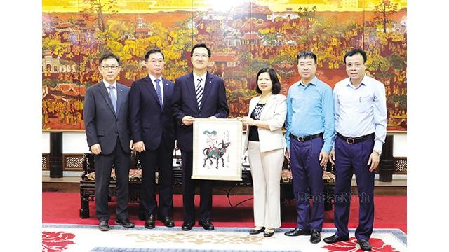 La présidente du Comité populaire provincial, Nguyên Huong Giang, présente un estampe populaire de Dông Hô à Ahn Soon Hong. Photo : baobacninh.com.vn