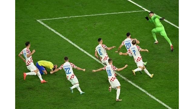 Les Croates célèbrent leur qualification pour les demi-finales de la Coupe du monde 2022, vendredi 9 décembre 2022, à Al-Rayyan (Qatar), après le tir au but manqué du Brésilien Marquinhos, agenouillé. INA FASSBENDER / AFP