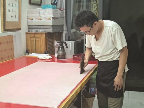 Bùi Tiên Phuc dans son atelier Han Nôm Duong, spécialisé en restauration de livres anciens et manuscrits. Photo : NVCC/CVN.
