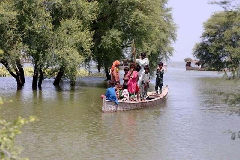 Des gens se rendent en bateau dans une zone inondée de la province du Sindh au Pakistan. Photo : Xinhua/VNA