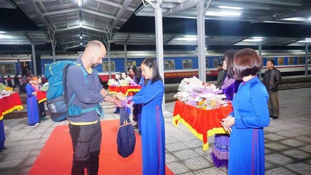 Des cadeaux aux premiers touristes étrangers à Lào Cai. Photo : VNA.