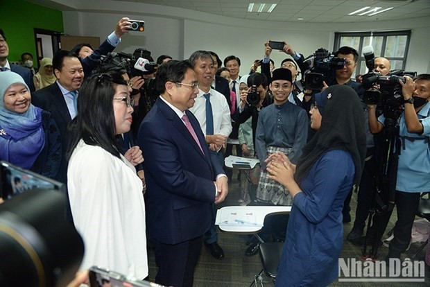 Le Premier ministre Pham Minh Chinh converse avec des étudiants brunéiens de vietnamien à l’Université de Brunei Darussalam (UBD). Photo : NDEL.
