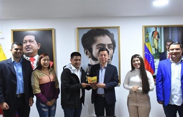 Le rédacteur en chef adjoint de la revue Communiste, Vu Trong Lâm (troisième à partir de la droite) présente un souvenir au vice-président du PSUV chargé des affaires d’organisation et président de l’Assemblée nationale vénézuélienne Pedro Infante. Photo : VNA.
