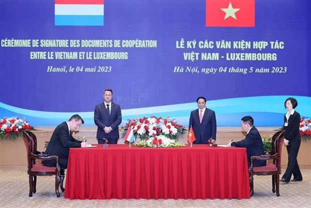 Le Premier ministre vietnamien, Pham Minh Chinh (debout, à droite), et le Premier ministre luxembourgeois, Xavier Bettel (debout, à gauche), ont assisté à la signature de documents de coopération. Photo : VNA.