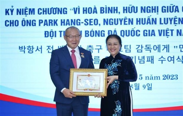 La présidente de l'Union des Organisations d’Amitié du Vietnam, l’ambassadrice Nguyên Phuong Nga, remet l'Insigne "Pour la paix et l'amitié entre les nations" à Park Hang-seo, le 9 mai à Hanoï. Photo : VNA.