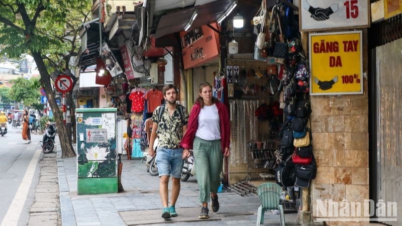 Des touristes étrangers se promènent dans la rue Hàng Dào (arrondissement de Hoàn Kiêm, capitale Hanoï). Photo : NDEL.