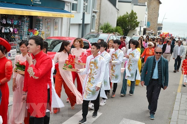 Des étudiants internationaux, des Vietnamiens en France et des Français en costumes nationaux et ao dài défilent ensemble dans les rues pour présenter les mariages traditionnels et le Nouvel An traditionnel vietnamien (le Têt). Photo : VNA.