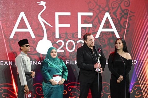 Au nom de la Vietnamienne Kim B, le réalisateur Aron Toronto (2e, droite) et son épouse Nha Uyen (1er, droite) recoivent son prix de la "Meilleure actrice dans un second rôle". Photo : comité d'organisation