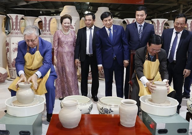 Le Président vietnamien Vo Van Thuong et son homologue kazakh Kassym-Jomart Tokayev (à gauche) essayant de mouler chacun un vase en argile. Photo: VNA