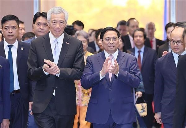 Le Premier ministre vietnamien Pham Minh Chinh (à droite) et son homologue singapourien Lee Hsien Loong participent à la conférence. Photo : VNA.
