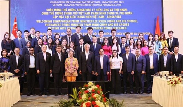 Le Premier ministre vietnamien Pham Minh Chinh, son homologue Lee Hsien Loong et leurs épouses et les jeunes exemplaires des deux pays. Photo : VNA.