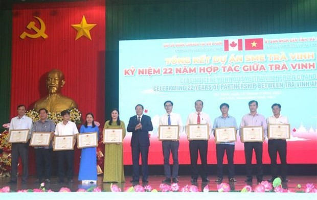 Le président du Comité populaire provincial Lê Van Han (au milieu) remet des satisfecit à des collectifs et particuliers ayant eu des contributions importantes à la mise en œuvre du projet de développement des PME de Trà Vinh. Photo : VNA.