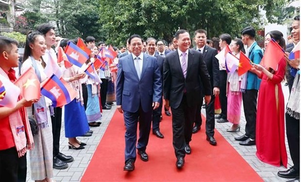 Les Premiers ministres Pham Minh Chinh (à gauche) et Samdech Moha Bovor Thipadei Hun Manet visitent l’Université du commerce extérieur à Hanoï. Photo : VNA.