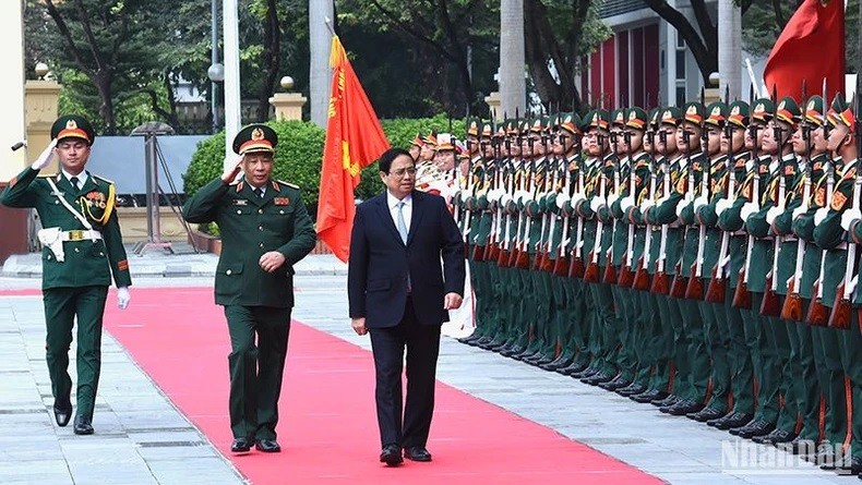 Le Premier ministre Pham Minh Chinh (à droite) inspecte la garde d’honneur de l’Académie de la Défense nationale. Photo : NDEL.