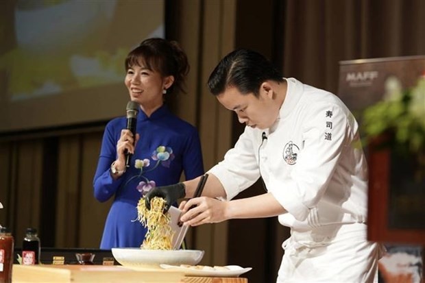 Un chef cuisinier démontre la préparation d'un plat à base de fruits de mer japonais lors de l'événement. Photo : VNA.