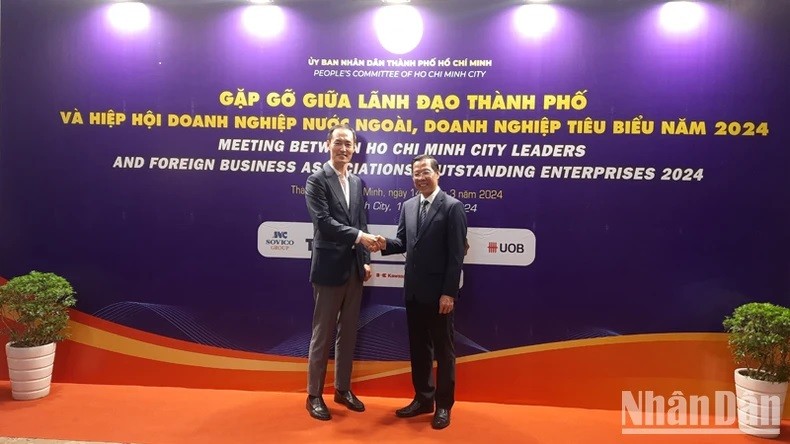 Le président du Comité populaire de Hô Chi Minh-Ville, Phan Van Mai (à droite) et un délégué lors de la rencontre, à Hô Chi Minh-Ville, le 14 mars. Photo : NDEL