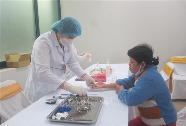 Une patiente se fait consulter par une médecin dans un établissement de santé à Hanoï. Photo : VNA.