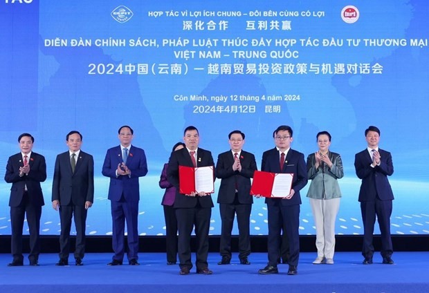 Le Président de l’ANV Vuong Dinh Huê supervise l'échange des protocoles de coopération entre les entreprises vietnamiennes et chinois, à Kunming, dans la province chinoise du Yunnan. Photo : VNA.